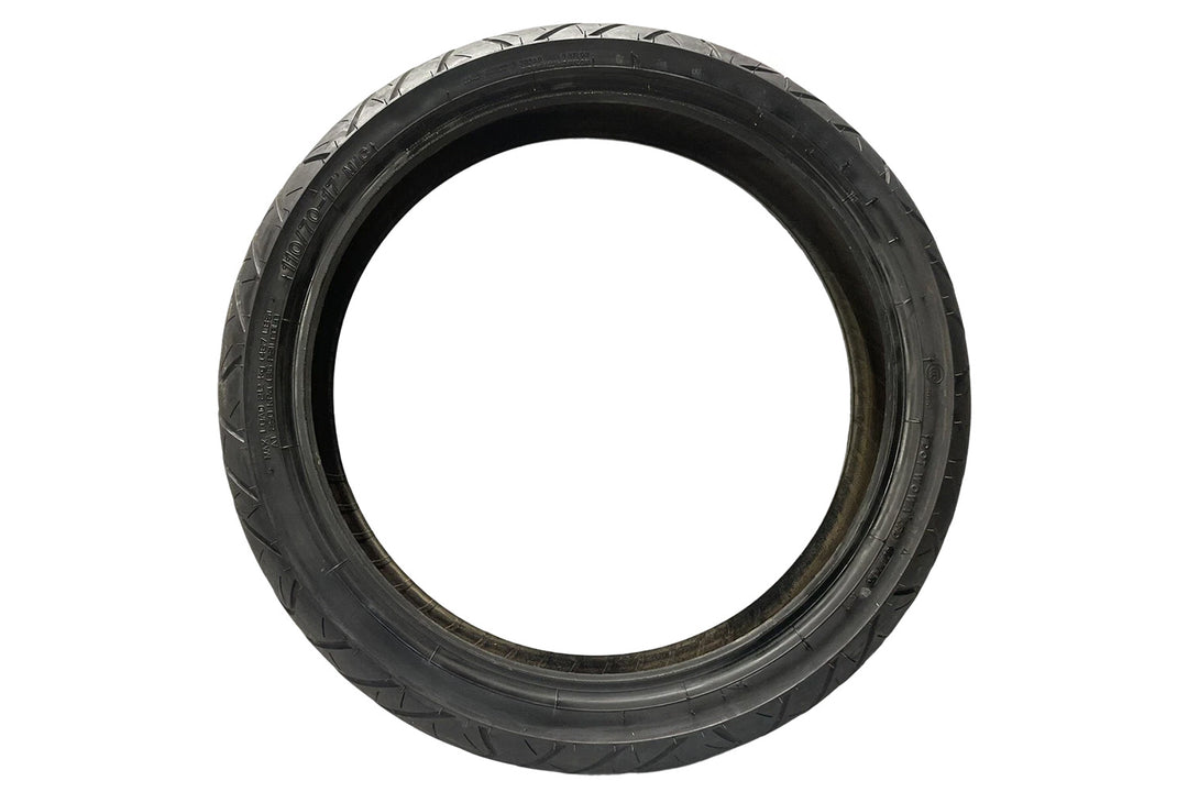 Angled profile of narrow motorcycle tire displaying shallow arc design and even tread spacing, crafted for efficient road grip, low friction, and consistent high-speed stability.